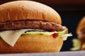 Close-up of delicious fresh home made burger with lettuce, cheese, onion and tomato on a rustic wooden plank on a dark Royalty Free Stock Photo