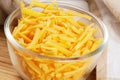 Close up of delicious Grated Cheddar Cheese on wooden background