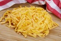 Close up of delicious Grated Cheddar Cheese on wooden background