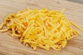 Close up of delicious Grated Cheddar Cheese on wooden background