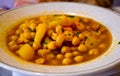 close up of a delicious home made white plate of chick peas with parsley, leek and shrimp ready on the table to be eaten. Royalty Free Stock Photo