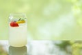 Delicious juicy fresh lemon soda on glass table Blurred leaf reflection background Royalty Free Stock Photo