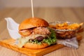 Close-up of a delicious meal for sharing, consisting of a large cheeseburger a plate of French fries Royalty Free Stock Photo