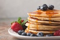 Close-up delicious pancakes, with fresh blueberries, strawberries and maple syrup on a light background. With copy space. Sweet m Royalty Free Stock Photo