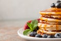 Close-up delicious pancakes, with fresh blueberries, strawberries and maple syrup on a light background. With copy space Royalty Free Stock Photo