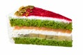 Close-up delicious piece of pink and green cake isolated on white background, pistachio sponge cake with slices of nuts, caramel,