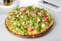 Close up Delicious Pizza with hamon and cherry tomato slices, parmezan cheese and arugula on the wooden board on t Royalty Free Stock Photo