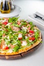 Close up Delicious Pizza with hamon and cherry tomato slices, parmezan cheese and arugula on the wooden board on t Royalty Free Stock Photo