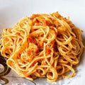 Spaghetti with red pesto sauce and crispy pork Royalty Free Stock Photo