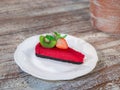 Close up delicious red velvet cake with fruit topping on the white plate isolate wood background Royalty Free Stock Photo