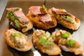 Close-up of delicious slices of meat decorated by parsley on white baguette slices