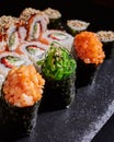Close up of delicious sushi set with rolls of California, sashimi and maki on a black plate. Royalty Free Stock Photo