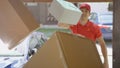 CLOSE UP: Delivery guy throws packages in someone's driveway on a sunny day.