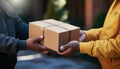 A close-up of a delivery man& x27;s hands delivering a package and a customer& x27;s hands picking it up at the front door