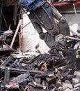 A demolition claw working picking up debris in the wreckage of a destroyed building Royalty Free Stock Photo