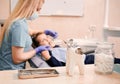 Dentist examining kid teeth in cabinet with dental instruments.