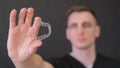 Close-up, a dentist demonstrates modern aligners for straightening teeth.