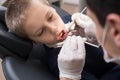 Pediatric dentist examining teeth of boy patient in dental clinic using dental tools - probe and mirror Royalty Free Stock Photo