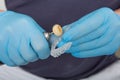 Close up on dentist hands covered with latex gloves shaping mouth guard with file equipment