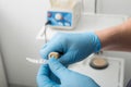 Close up on dentist hands covered with latex gloves shaping mouth guard with file equipment