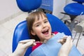 A close-up of a dentistÃ¢â¬â¢s hands and a child with an opened mouth