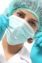Close up of a dentist woman with a mask holding tools ready to operate