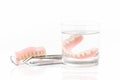 close up of dentures in glass of water and dental tool, dental mirror on white background Royalty Free Stock Photo