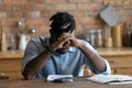 Close up depressed exhausted African American man sitting at table