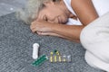 Close up depressed mature woman lying on bed with meds Royalty Free Stock Photo