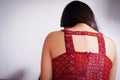 Close up of a depressed woman, wearing a red blouse with her head down after being raped and suffering sexual abuse, in