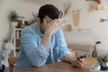 Close up depressed young man holding credit card and smartphone