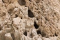 Close up of desert rock wall with deep dark holes and cracks on the surface Royalty Free Stock Photo