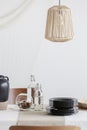 Close-up of designed beige lamp above table