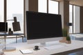 Close up of designer office workplace with empty black computer monitor, window with city view, decorative items and supplies. Royalty Free Stock Photo