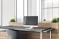 Close up of desk with empty mockup laptop with reflections in modern wooden office interior with window and city view. 3D Royalty Free Stock Photo