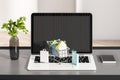 Close up of desk with laptop and tiny shopping carts on keaybord. Blurry wall background. Online shopping and commerce concept. 3D