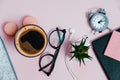 Close Up Desk on pink glasses notepad kicking pencils plant macaroons alarm clock Top View