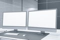 Close up of desktop with empty white computer screens in futuristic server room office interior. Big data and storage concept. Royalty Free Stock Photo