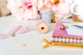 Close up Desktop handmade scrapbooking DIY tools. White working table background. Flat lay ribbons, tapes, peonies, golden paper