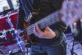Bassist's Hand on Bass Guitar Fretboard During Live Performance