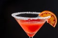 Close-up detail of cocktail glass with blood orange martini and sugar, on black background, horizontally Royalty Free Stock Photo