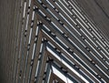Close up detail of the corner of a large modern office building with geometric metallic steel lines
