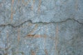 Close up detail of a cracked grey concrete wall with faint graffiti. Royalty Free Stock Photo