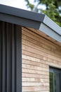 close up detail of dark grey alucobond cladding on the roof, wood slats behind it, contemporary architecture Royalty Free Stock Photo