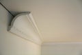 Close-up detail of decoration white molding connected with glue adhesive to wall and ceiling in interior room renovation and Royalty Free Stock Photo