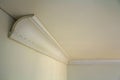 Close-up detail of decoration white molding connected with glue adhesive to wall and ceiling in interior room renovation and Royalty Free Stock Photo