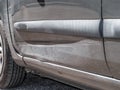 Close up detail of a dented driver door from a car crash or automobile accident.