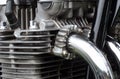 Detail of the engine block of an old vintage motorcycle with black frame and shiny chrome exhaust pipes Royalty Free Stock Photo