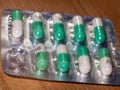 close up detail of foil packet of green and white prozac painkiller tablets on table surface Royalty Free Stock Photo