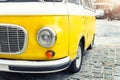 Close-up detail front view of headlight part old vintage bright yellow retro mini bus car van parked in european city Royalty Free Stock Photo